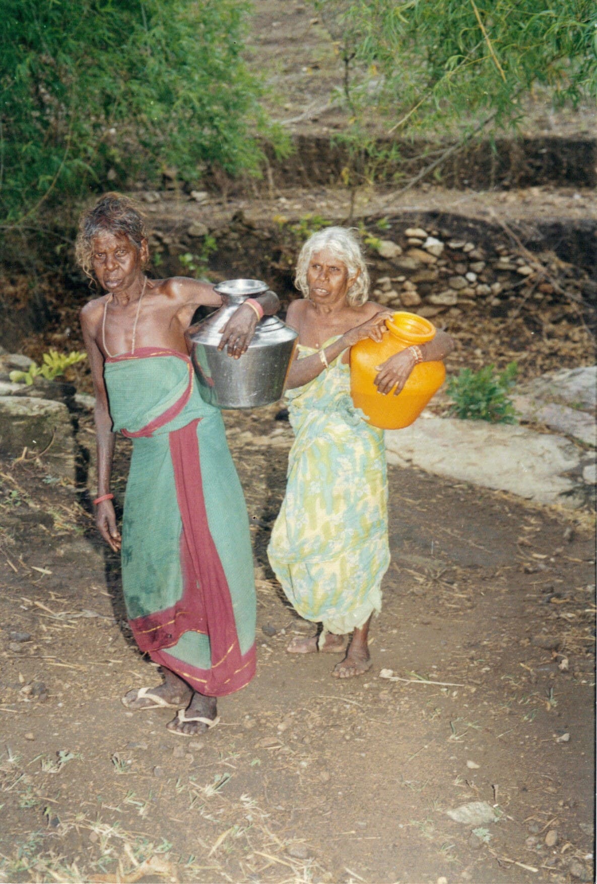 Tribal women carrying water pots for the long trek home